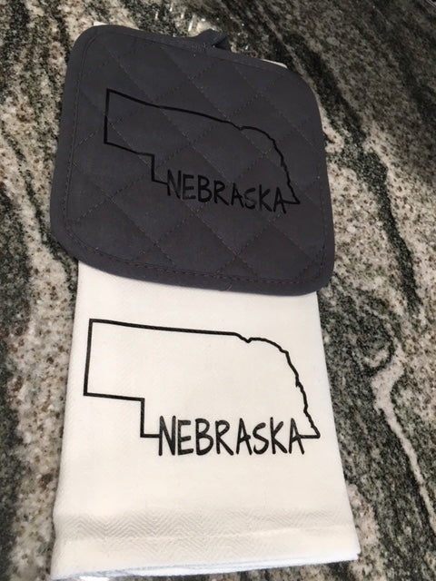 Nebraska on bottom of State Towel with gray hot pad